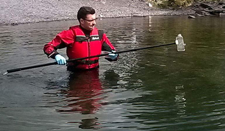 Man testing the water quality at llyn padarn Man testing the water quality at llyn padarn