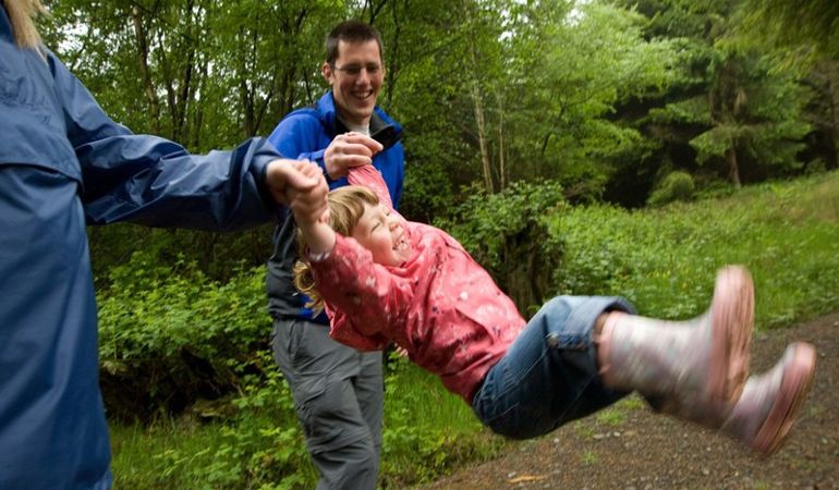 Child on swing with parents Child on swing with parents