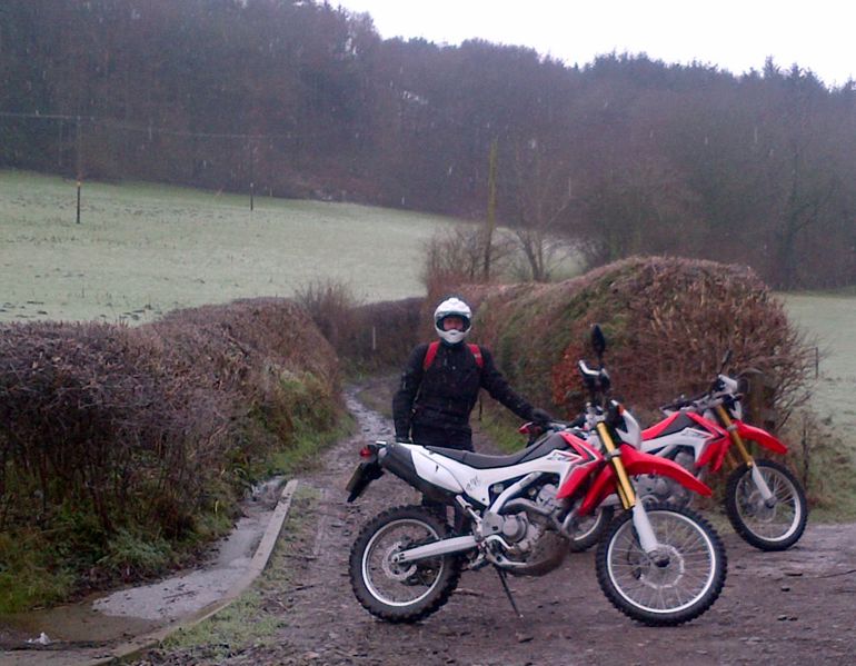 Man standing next to scrambler bikes Man standing next to scrambler bikes