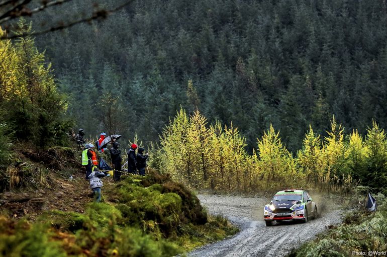 Rally car on mountain road with trees in the background Rally car on mountain road with trees in the background