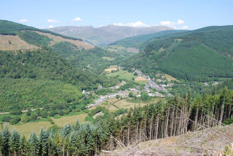 A Valley surrounded by trees and mountains A Valley surrounded by trees and mountains