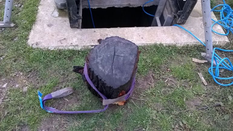 A large log on the ground next to the opening to the tidal flap with a lifting strap attached A large log on the ground next to the opening to the tidal flap with a lifting strap attached