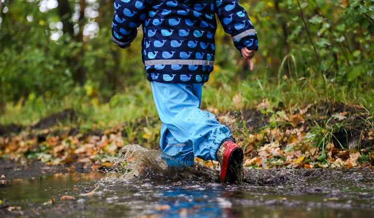 Child walking through puddles Child walking through puddles