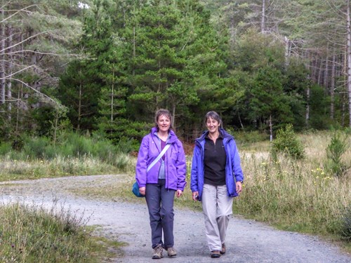 Two women walking in Newborough Forest